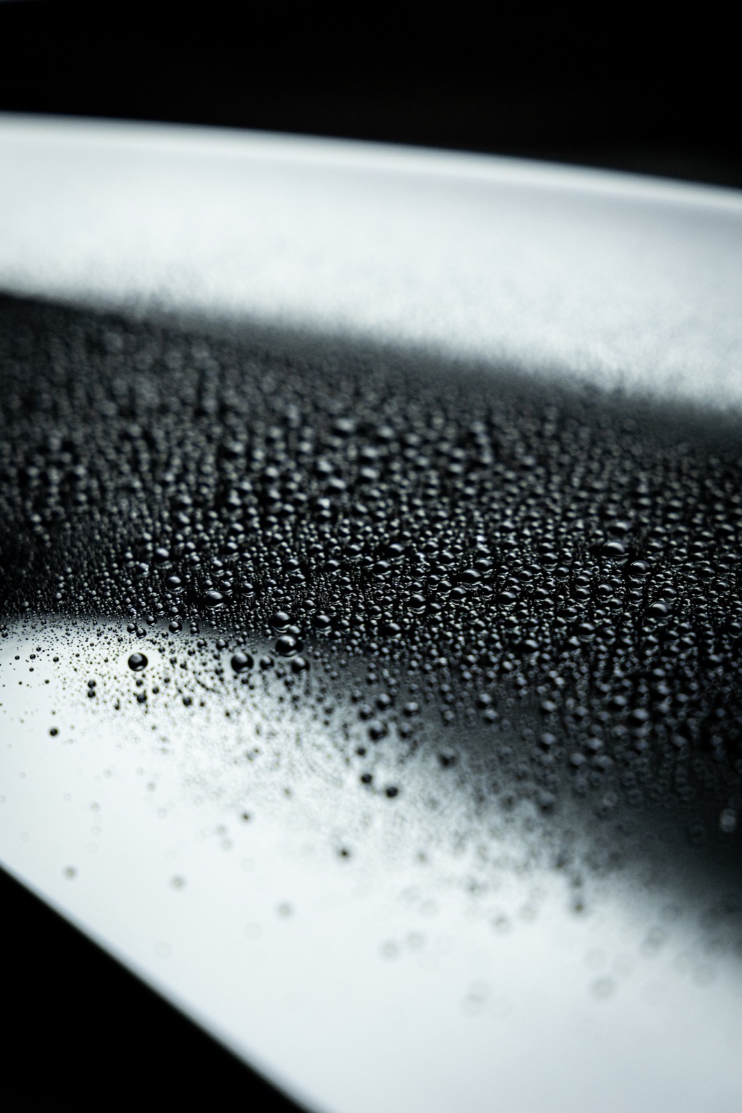 Water beading tightly on a dark panel protected with Gtechniq C2 Ceramic Sealant